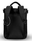 Flat view of the back of Sherpani’s Anti-Theft bag, the Soleil AT. The back is entirely black, and has vegan leather accents in black. Two elastic water bottle holders sit on either side of the bag. A chair lock loop is clipped to the upper left side. There is an external sleeve with a zipper at the bottom, which creates the luggage pass-through or trolley sleeve. It has padded backpack straps, short tote handles, and a place to attach a crossbody strap.
