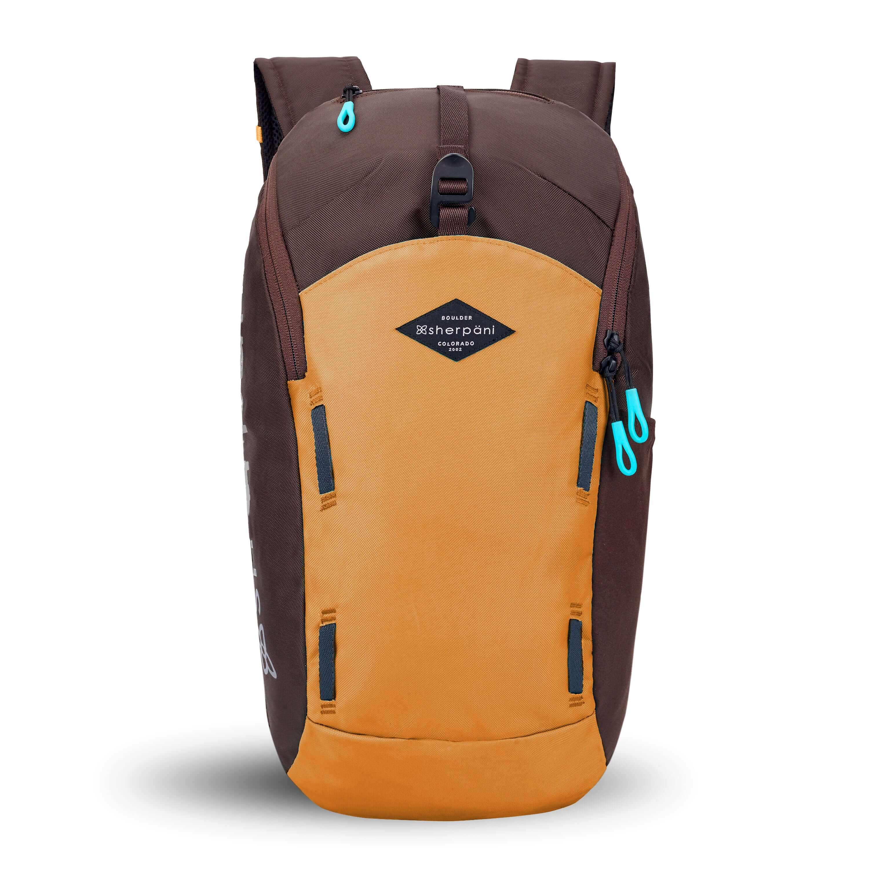 Flat front view of Sherpani backpack, the Switch in Sundial. The bag is two-toned in burnt yellow and brown. Easy-pull zippers are accented in aqua. At the top is a metal buckle that connect to an external pouch on the front panel. It has adjustable and padded backpack straps. There is a daisy chain feature on the front panel. 