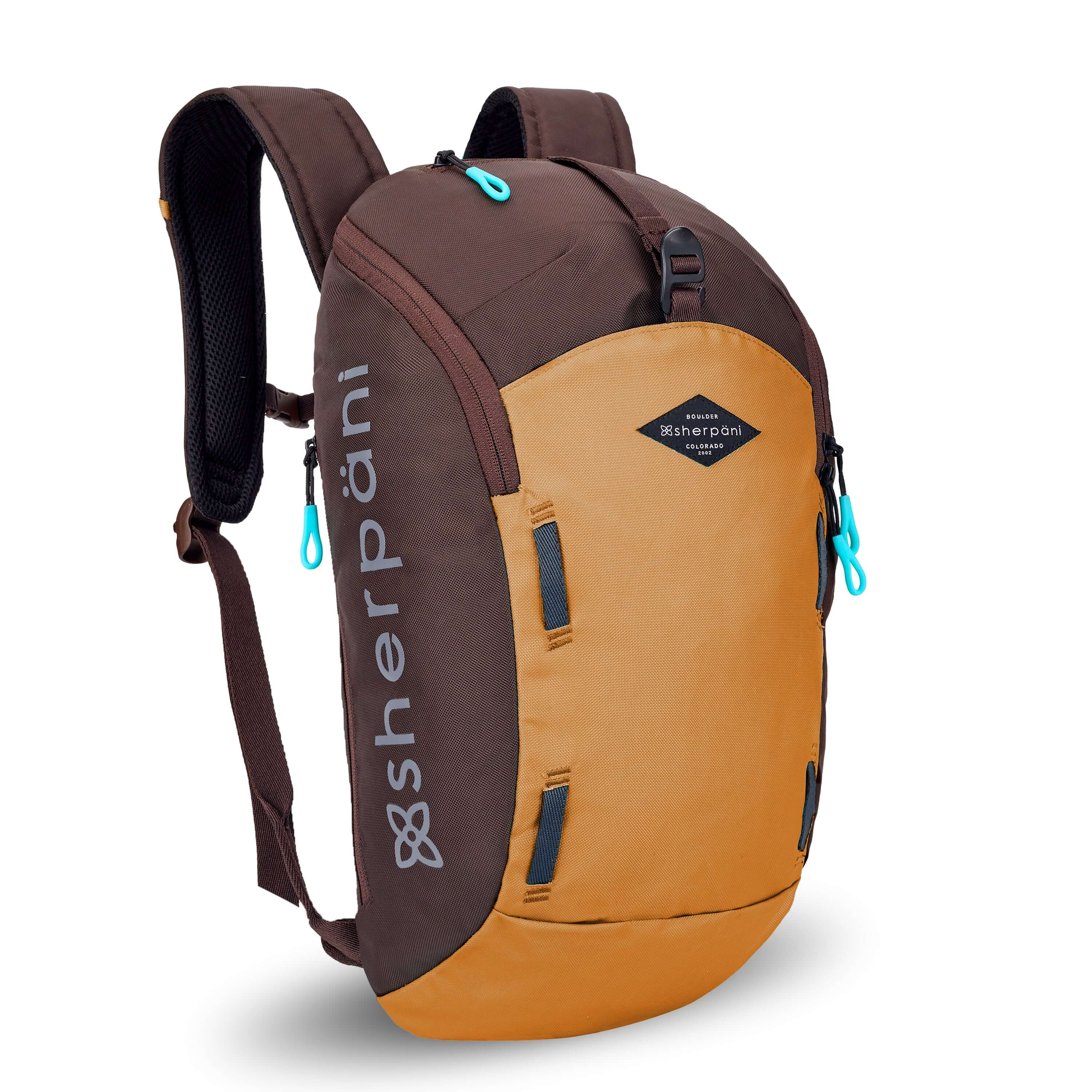 Angled front view of Sherpani backpack, the Switch in Sundial. The bag is two-toned in burnt yellow and brown. Easy-pull zippers are accented in aqua. At the top is a metal buckle that connect to an external pouch on the front panel. It has adjustable and padded backpack straps. There is a daisy chain feature on the front panel. #color_sundial