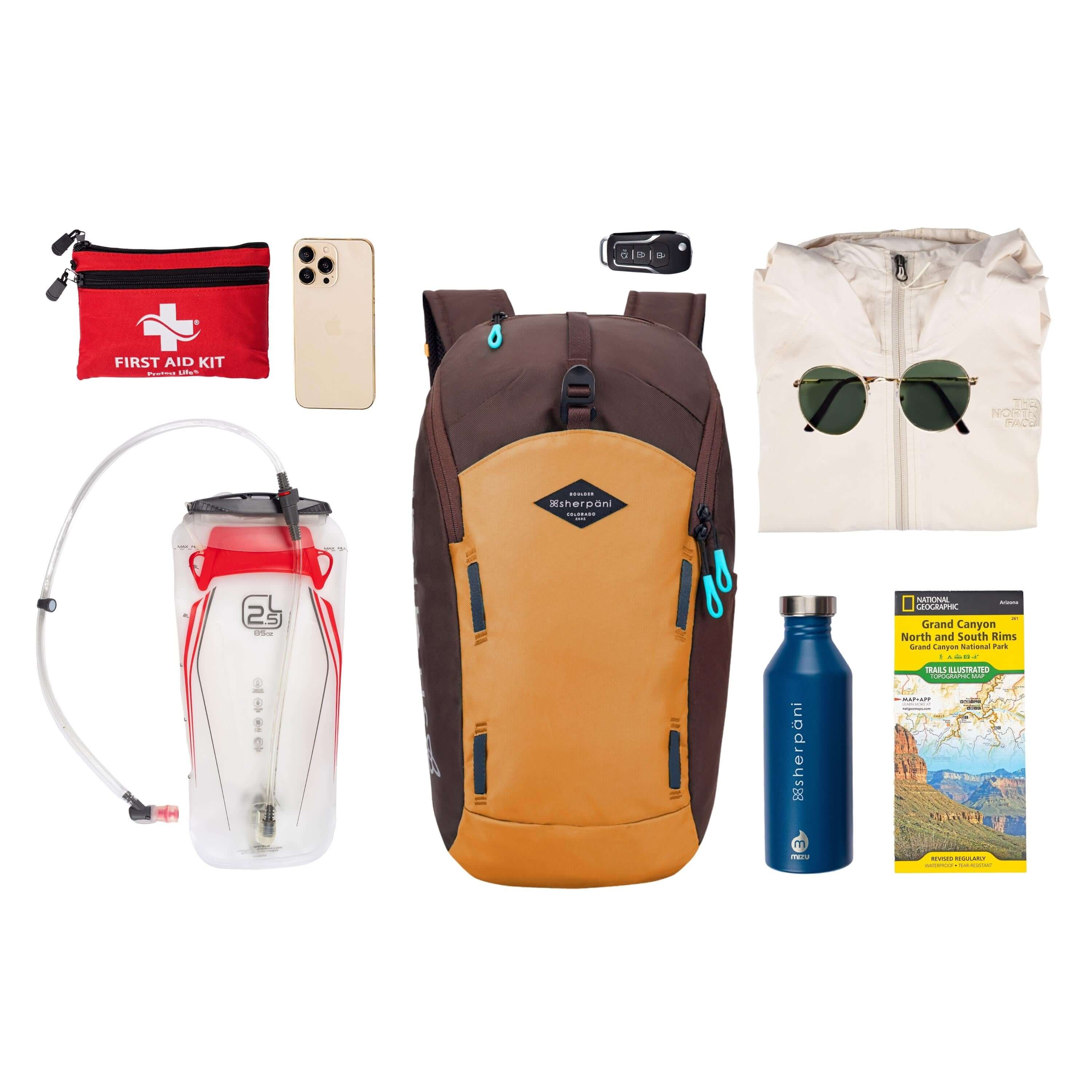 Top view of example items to fill the bag. Sherpani backpack, the Switch in Sundial, lies in the center. It is surrounded by an assortment of items: first aid kit, phone, hydration reservoir, car key, rain jacket, sunglasses, water bottle and hiking guide.