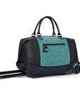 Angled front view of Sherpani’s Anti Theft rolling Duffle, the Trip in Teal, with vegan leather accents in black. The bag lies flat on the ground with the luggage handle extended on the left side and the rolling wheels shown on the right side. The bag features short tote handles at the top and an external zipper compartment on the front panel with locking zipper and ReturnMe tag.