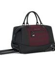 Angled front view of Sherpani’s Anti Theft rolling Duffle, the Trip in Merlot, with vegan leather accents in black. The bag lies flat on the ground with the luggage handle extended on the left side and the rolling wheels shown on the right side. The bag features short tote handles at the top and an external zipper compartment on the front panel with locking zipper and ReturnMe tag.