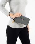 A model holding Sherpani womens wallet with RFID protection, the Tulum in Juniper.