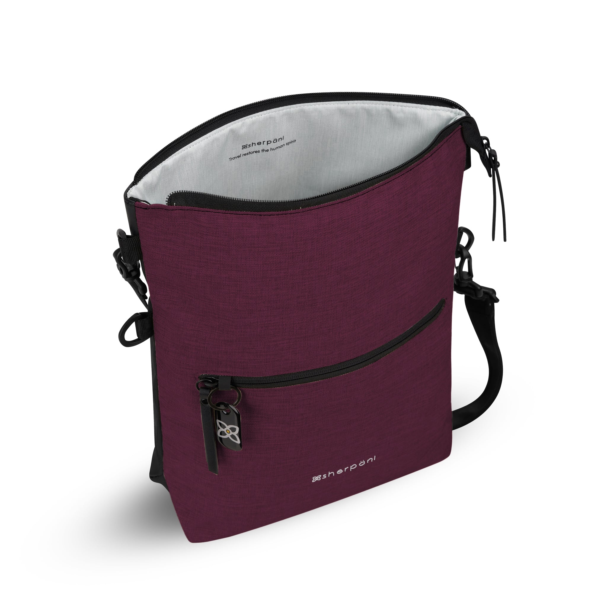 Top view of Sherpani’s Anti-Theft bag, the Vale AT in Merlot. The main zipper compartment is open to reveal a pale blue interior. A chair loop lock is clipped to the side of the bag. The front features an external compartment with a locking zipper and ReturnMe tag. An adjustable/detachable crossbody strap is attached to the bag. 