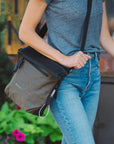 Close up view of a woman walking outdoors with Sherpani reversible bag, the Vale in Loden, as an Anti-Theft crossbody purse.