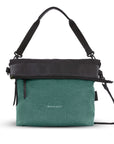 Flat front view of Sherpani's Anti-Theft bag, the Vale AT in Teal with vegan leather accents in black. The top is folded over creating a two-toned reversible overlap. It has an adjustable/detachable crossbody strap, and a second detachable strap fixed at a shorter length.