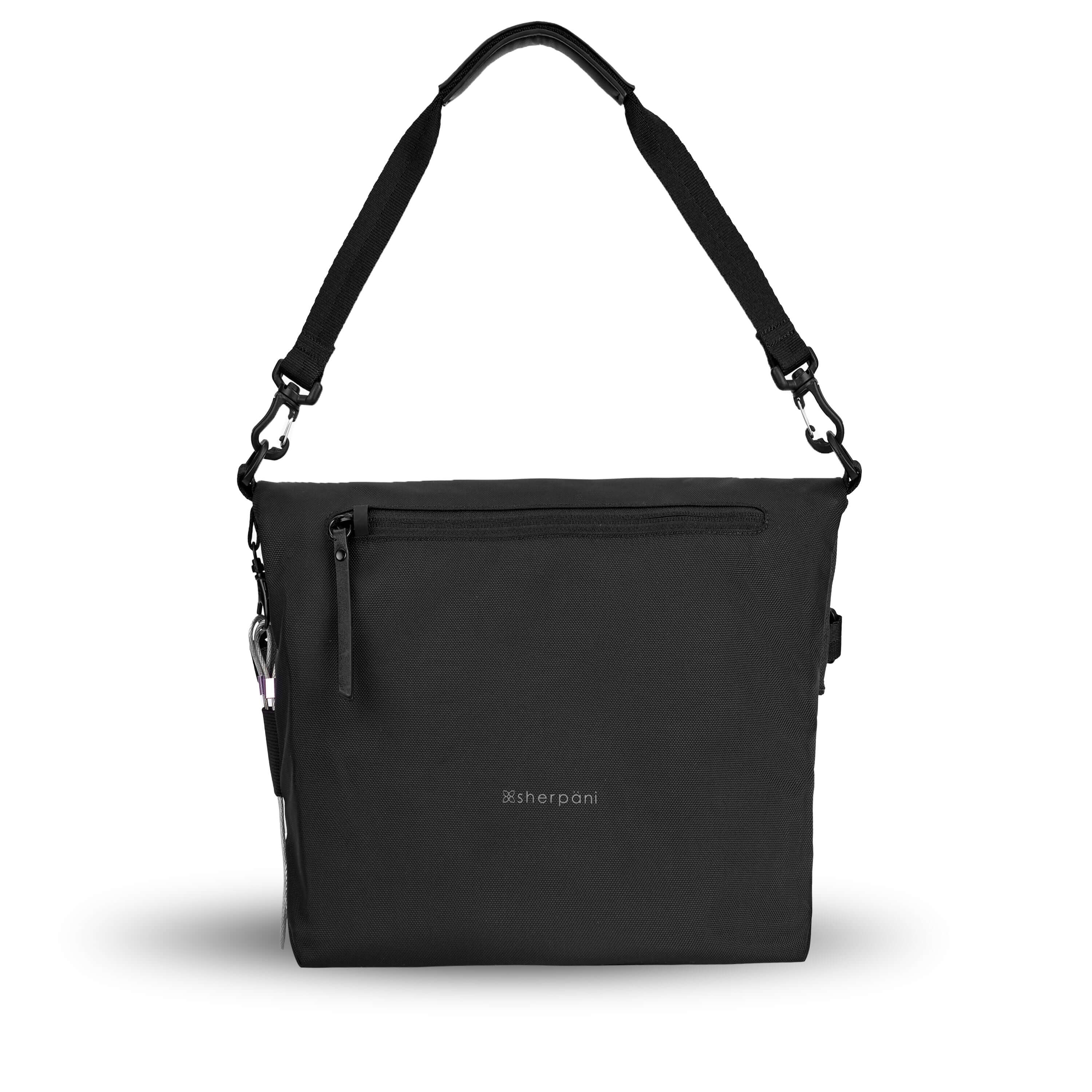 Flat view of the back of Sherpani’s Anti-Theft bag, the Vale AT. The back is entirely black, and has vegan leather accents in black. There is an external pocket with a locking zipper, a chair loop lock on one side, and a detachable short tote handle clipped onto the bag. 