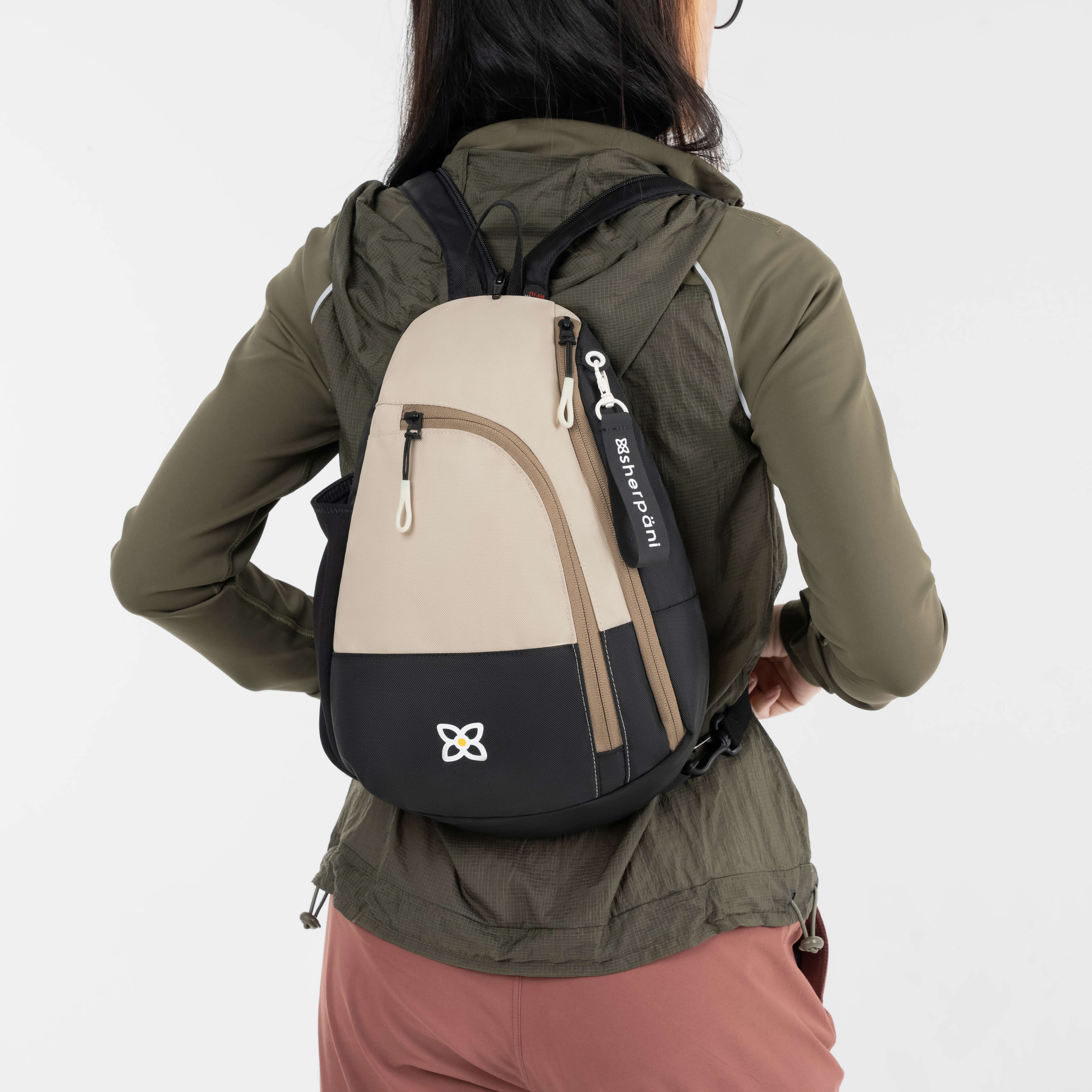 A model wearing the Wayfarer in Con Leche as a backpack with two straps. 