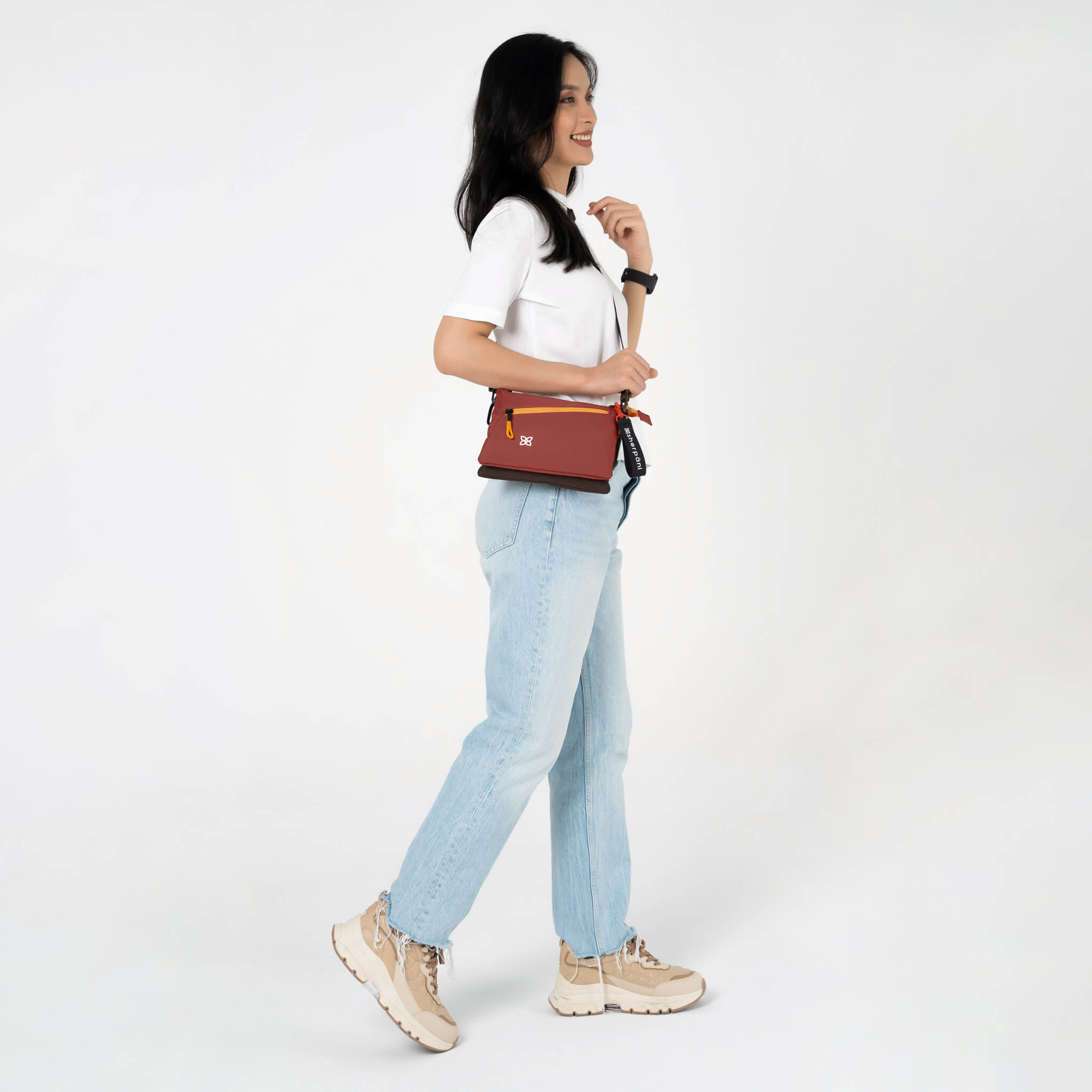 A model wearing Sherpani crossbody travel bag with RFID, the Zoom in Cider. 