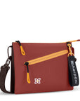 Angled front view of Sherpani small crossbody bag, the Zoom in Cider. Special features of the Zoom include RFID protection, adjustable crossbody strap, removable strap, removable keychain, outside zipper pocket, internal divider, internal zipper pockets and back slip pocket. The Cider color is two-toned in dark brown and burgundy with yellow accents.