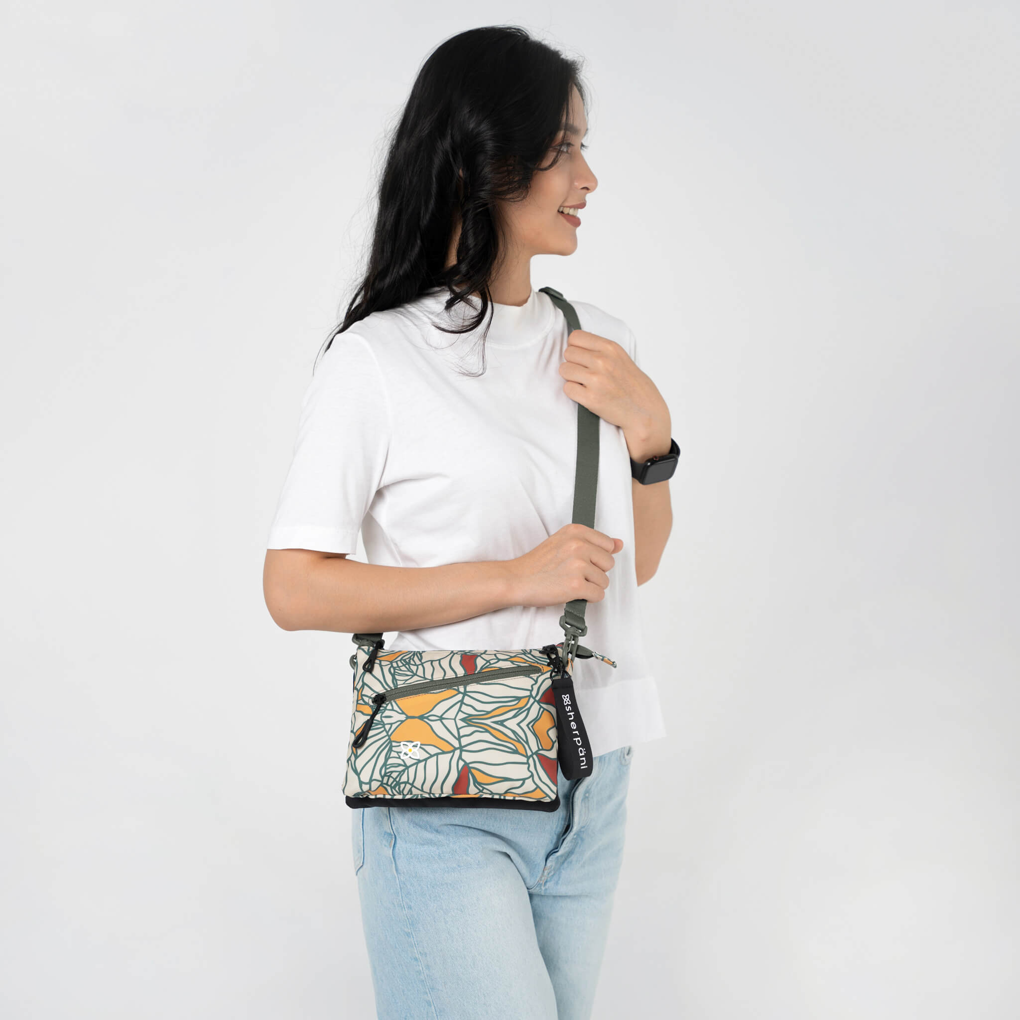A model wearing Sherpani RFID bag, the Zoom in Fiori, as a crossbody travel purse. 