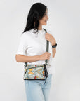 A model wearing Sherpani RFID bag, the Zoom in Fiori, as a crossbody travel purse.