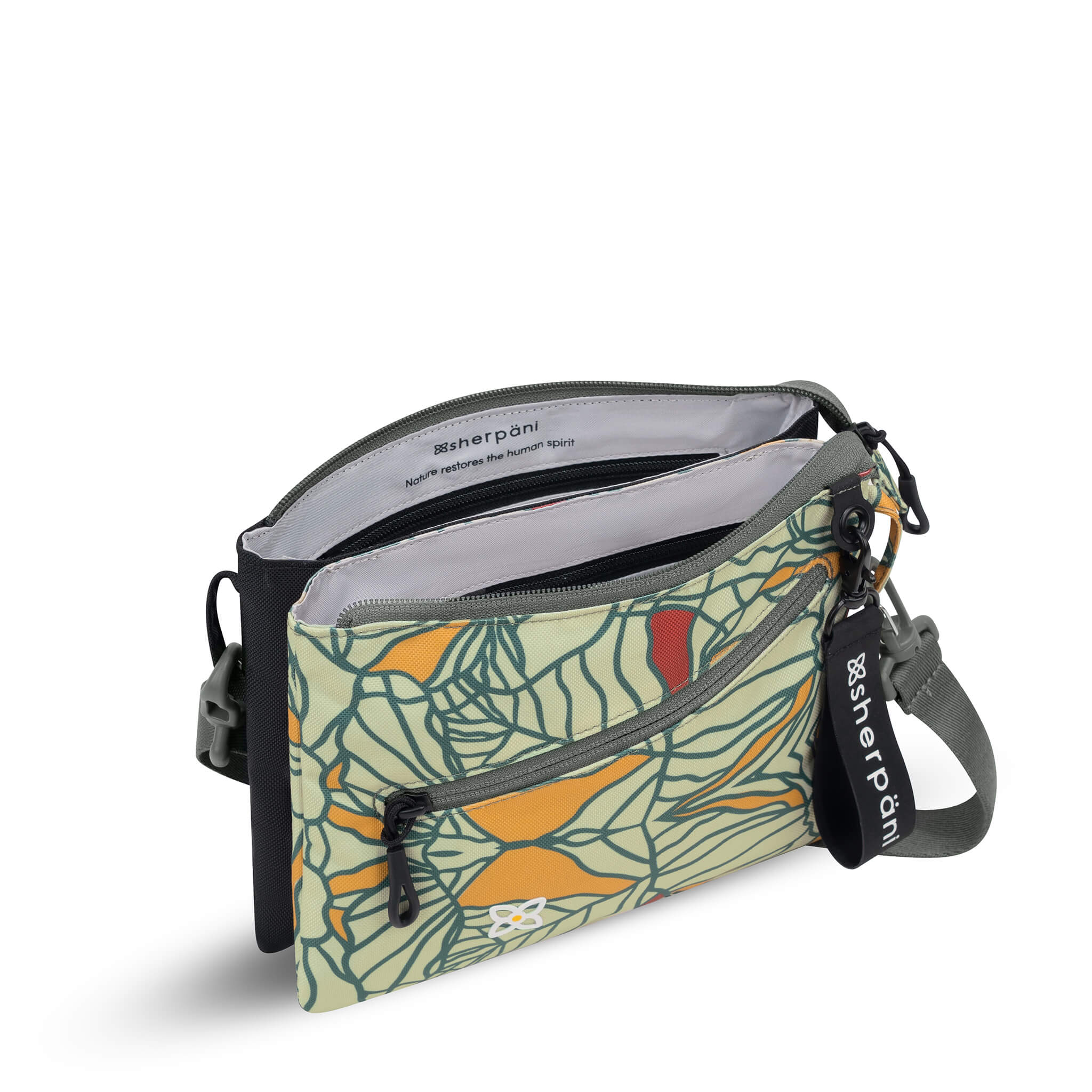 Inside view of Sherpani crossbody travel bag, the Zoom in Fiori. It is unzipped reveal an internal divider that separates the main bag compartment in two. Text inside reads "Sherpani: Nature restores the human spirit." 