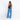 A woman wearing a Sherpani Wayfarer Chromatic Black Convertible Sling on her back against white background.  #color_chromatic-black
