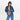 Woman holding a Sherpani Izzie Dune Water Bottle Crossbody by handheld straps on white background.  #color_dune-tan