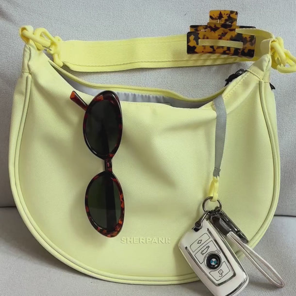 Multiple angles of items that fit in Sherpani Mina Sol Yellow Medium Crossbody Bag, including phone, wallet, glasses, & more.