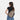Woman wearing a Sherpani Esprit Dune Sling on her back against white backdrop. #color_dune-tan