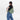 Woman wearing a Sherpani Esprit Olivine Sling on her back against white backdrop. #color_olivine-green
